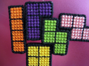 close up of cross stitched tetris magnets