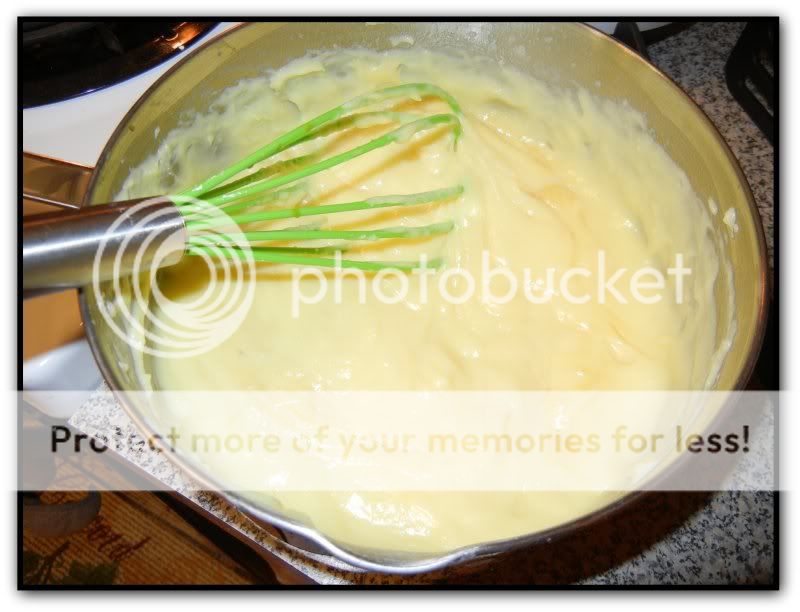 boston cream mixture in a pot with a green whisk 