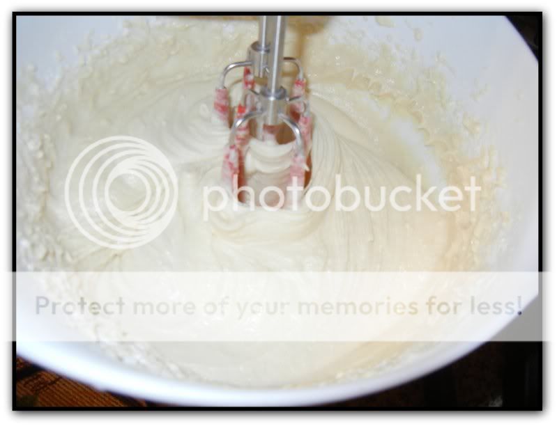 mixing all ingredients together in a white bowl with a hand mixer 