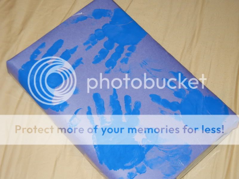 present wrapped in purple wrapping paper with blue handprints 